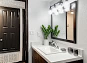 Thumbnail 12 of 18 - a bathroom with a sink and a mirror at The Lorient Apartments, Pensacola, Florida