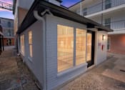 Thumbnail 13 of 16 - the front of a white building with glass windows