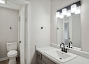 Thumbnail 10 of 16 - a bathroom with a sink and a toilet and a mirror