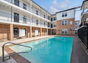 Thumbnail 11 of 16 - the pool is in front of an apartment building with a pool