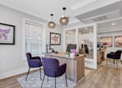 Thumbnail 14 of 16 - a living room with purple chairs and a reception desk
