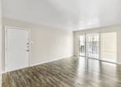 Thumbnail 2 of 9 - A room with wooden flooring and a white door.