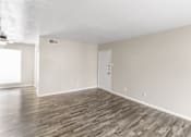 Thumbnail 6 of 9 - A room with wooden flooring and a white door.