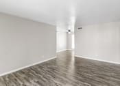 Thumbnail 5 of 9 - A room with wooden flooring and white walls.