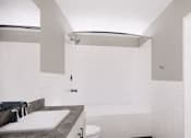 Thumbnail 6 of 6 - A white bathroom with a sink, toilet and bathtub.