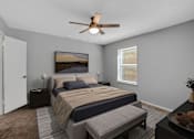 Thumbnail 7 of 9 - A bedroom with a bed, a bench, and a ceiling fan.