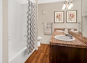 Thumbnail 4 of 5 - A bathroom with a marble countertop and a shower with a patterned curtain.