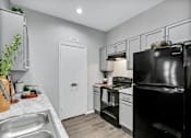Thumbnail 2 of 20 - a kitchen with black appliances and white cabinets