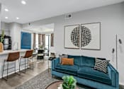 Thumbnail 7 of 20 - a living room with a blue couch and a dining room