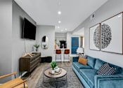 Thumbnail 10 of 20 - a living room with a blue couch and a tv