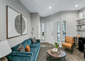 Thumbnail 8 of 20 - a living room with a blue couch and a coffee table