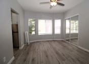 Thumbnail 4 of 59 - an empty living room with a ceiling fan and windows