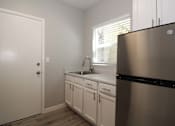 Thumbnail 12 of 59 - a kitchen with white cabinets and a stainless steel refrigerator