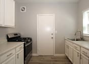 Thumbnail 13 of 59 - a small laundry room with white cabinets and a sink