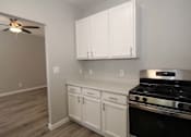 Thumbnail 14 of 59 - a kitchen with white cabinets and a stove and a ceiling fan