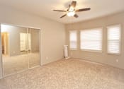 Thumbnail 19 of 59 - an empty bedroom with a ceiling fan and a mirror