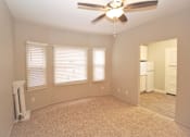 Thumbnail 21 of 59 - an empty living room with a ceiling fan and three windows