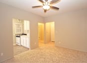Thumbnail 22 of 59 - an empty living room with a ceiling fan and a kitchen