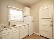 Thumbnail 25 of 59 - a kitchen with white cabinets and a sink and a refrigerator
