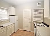 Thumbnail 27 of 59 - a kitchen with white cabinets and a stove and a refrigerator