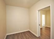 Thumbnail 33 of 59 - a empty room with wood flooring and a door to a hallway
