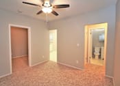 Thumbnail 37 of 59 - an empty room with a ceiling fan and a bathroom