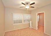 Thumbnail 38 of 59 - a bedroom with a large window and a ceiling fan