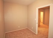 Thumbnail 41 of 59 - a empty room with a carpeted floor and a door to a hallway