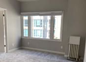 Thumbnail 49 of 59 - an empty living room with a ceiling fan and a window