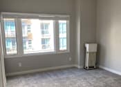 Thumbnail 51 of 59 - an empty living room with a ceiling fan and three windows
