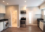 Thumbnail 54 of 59 - a renovated kitchen with stainless steel appliances and a laundry room