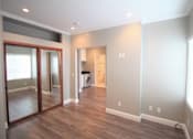 Thumbnail 55 of 59 - a living room with a large mirror and a wooden floor