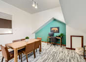 Thumbnail 5 of 28 - A room with a wooden table and chairs, a green wall, and a picture of a bear on the wall.