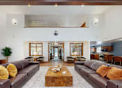 Thumbnail 3 of 28 - A living room with brown leather couches and a coffee table in the center.