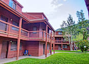 Thumbnail 11 of 17 - a large wooden house with a porch and a lawn
