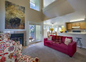 Thumbnail 11 of 28 - a living room with a red couch and a fireplace