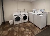 Thumbnail 4 of 6 - A laundry room with a washer and dryer.