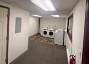 Thumbnail 5 of 6 - A laundry room with a washer and dryer.