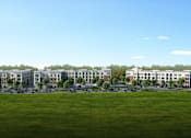 Thumbnail 3 of 4 - A large grassy field with a row of buildings in the distance at Manor East Apartments, Manor, 78653