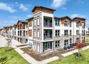 Thumbnail 5 of 19 - an exterior view of a row of apartment buildings on a sunny day at Creekside at Grand Prairie, Grand Prairie, Texas, 75052