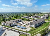 Thumbnail 3 of 19 - an aerial view of an apartment complex in a city at Creekside at Grand Prairie, Grand Prairie, 75052