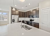 Thumbnail 12 of 19 - a kitchen with a sink and a refrigerator at Creekside at Grand Prairie, Grand Prairie, TX