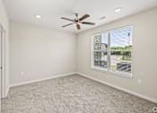 Thumbnail 18 of 19 - an empty living room with a ceiling fan and a window at Creekside at Grand Prairie, Grand Prairie, Texas, 75052