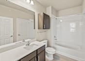 Thumbnail 17 of 19 - a bathroom with a shower sink and toilet and a mirror at Creekside at Grand Prairie, Grand Prairie, TX