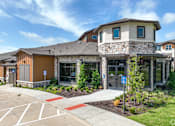 Thumbnail 6 of 19 - a building with stone and wood exterior and a sidewalk in front of it at Creekside at Grand Prairie, Grand Prairie, TX