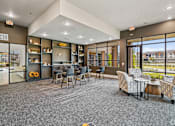 Thumbnail 9 of 19 - a lounge area with chairs and tables and large windows at Creekside at Grand Prairie, Grand Prairie, Texas