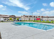 Thumbnail 11 of 19 - the preserve at ballantyne commons community swimming pool with apartment buildings in the background at Creekside at Grand Prairie, Grand Prairie, Texas, 75052