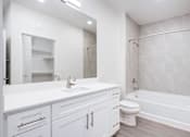 Thumbnail 13 of 17 - A white bathroom with a sink, toilet, and bathtub.