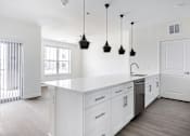 Thumbnail 1 of 17 - A kitchen with white cabinets and a white counter top.