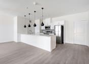 Thumbnail 2 of 17 - A kitchen with a white counter and a refrigerator.